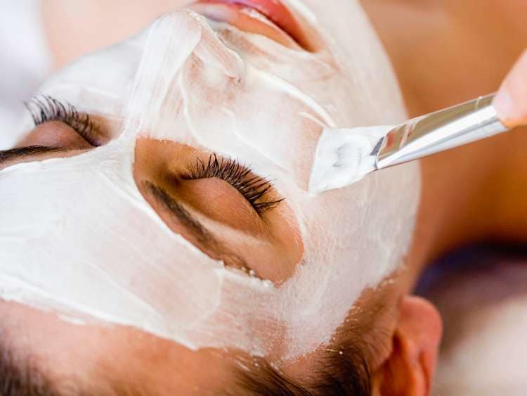 A women getting a facial mask applied at a health spa.